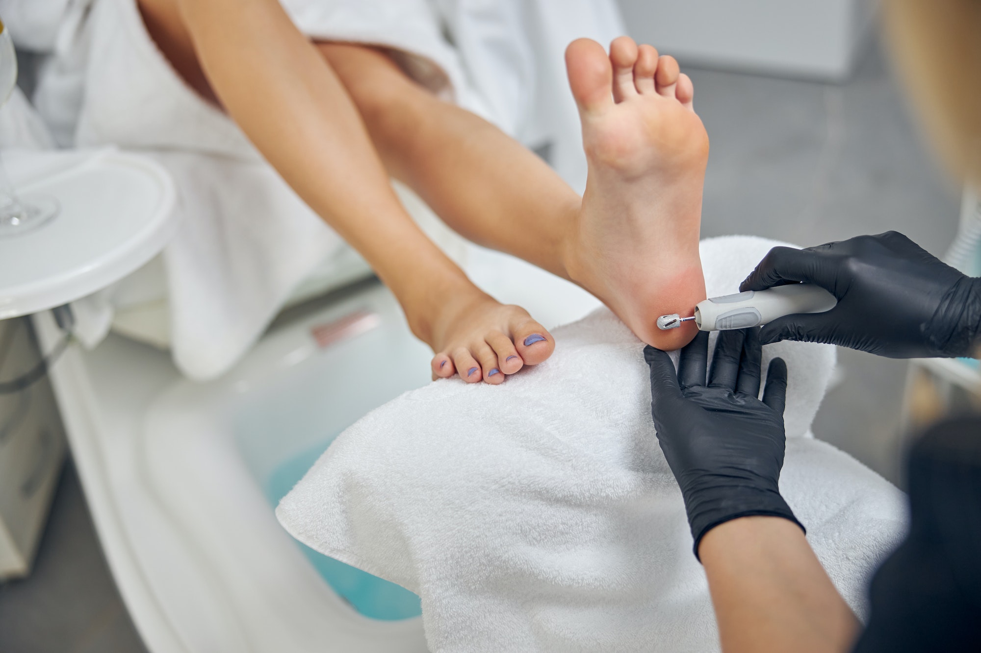 Woman visiting beautician for hardware pedicure in salon